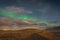 Aurora Borealis in Iceland northern lights shining green over hiking path in Iceland