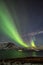 Aurora Borealis in Tromso, Norway in front of Norwegian fjord at winter