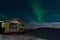 Aurora and a small wooden house