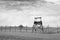 AUSCHWITZ, POLAND - March 30 2012 Empty Wooden watch tower standing by a wired fence in a concentration camp with rests