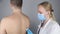 Auscultation. The therapist listens to the patient lungs. The man complains of coughing and difficulty breathing. A doctor in a go