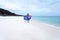 Aussie girl walking along pristine beach with Australian flag