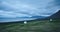 The austere Icelandic landscape with field in the foreground and the mountains and the fjords in the background