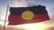 Australia Aboriginal flag waving in the wind, sky and sun background