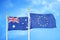 Australia and European Union two flags on flagpoles and blue cloudy sky