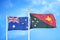 Australia and Papua New Guinea two flags on flagpoles and blue cloudy sky