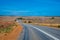 Australian bush road leading through dry landscape and farmland with speed limit