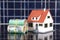 Australian dollar bills and house model on solar panel background