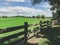 Australian farmland landscape - wooden fence near green hill.