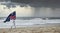 Australian flag blowing in the wind held by a female jogging on a Aussie beach