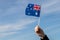 Australian flag in hand in the wind against the sky, country freedom, patriotism, Public Holiday, patriotic festival