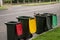 Australian garbage wheelie bins with colourful lids lined up on the street