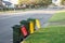 Australian garbage wheelie bins with colourful lids for recycling and general household waste lined up on the street kerbside