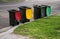 Australian garbage wheelie bins with colourful lids for recycling household waste and green garden waste lined up on the street