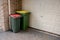 Australian garbage wheelie bins with red and yellow lids for general and recycling household waste near the resedential building