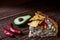 Australian meat pie on the table and avocado, chilli, chips a horizontal top view, rustic style.