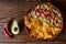 Australian meat pie on the table and avocado, chilli, chips a horizontal top view, rustic style.