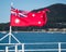 Australian red ensign flag flying from the stern of boat with a natural scene in background