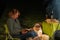 Australian Shepherd dog is lying by the campfire, the kettle is cooking and steaming, The woman is reading a book