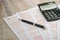 Australian tax return, calculator, pen on a wooden table. Close-up.