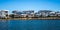 Australian waterside houses and condominiums with rock sea wall against blue sky