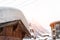 Austrian alpine village scenic landscape with wooden barn roof covered by thick snow layer after blizzard and snowsorm. Pine