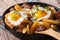 Austrian food: fried potatoes with meat and eggs in a pan closeu