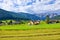 Austrian village among meadows fields and Alpine