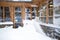 Austrian wooden house with big windows covered by snow at snowstorm