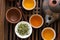 Authentic Chinese tea ceremony setting. Freshly brewed beverage poured in cups pot utensils on wooden tray. Loose tea leaves