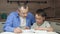 authentic family. Father and son are enthusiastically reading a book sitting at the table. A mature man and a child. The