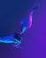 Authentic hand pouring pure water splash from wine or champagne glass over bright blue gradient background in neon light