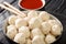 Authentic Indonesian boiled chicken meatballs Bakso served with hot sauce close-up in a bowl. horizontal
