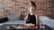 A authentic little girl is eating spaghetti pasta with nuggets and tomato with a fork at the table