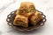 Authentic Middle Easter desserts concept with close up on Turkish baklava on small metal plate beautifully orate with Arabic