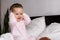 Authentic portrait caucasian little infant chubby baby girl or boy in pink sleepy upon waking looking at camera smiling