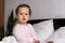 Authentic portrait cute caucasian little infant chubby baby girl or boy in pink sleepy upon waking looking at camera in