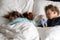 Authentic portrait cute caucasian little preschool siblings baby boy and girl in blue sleep with teddy bear on white bed