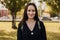 Authentic portrait of smiling brunette woman in black dress in summer Park