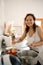 Authentic pretty woman, a housewife smiling looking at camera, preparing a delicious dinner in a minimalist kitchen