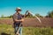 Authentic rural farmer check sharpness scythe. Agriculture worker. Vegetable garden. Farm implements. Rustic background. Work