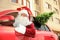 Authentic Santa Claus with fir tree and bag full of presents on roof driving modern car