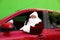 Authentic Santa Claus with fir tree driving car