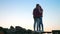 Authentic shooting of couple standing on stones on sky background, holding each other,true love vibes, amazing view