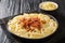 Authentic Swiss alplermagronen is pasta with potatoes and cheese and fried onions, bacon close-up on the table. horizontal