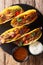Authentic tacos with glazed chicken, microgreen and vegetables are served with sauces close-up. Vertical top view