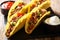 Authentic tacos with minced beef, cheese and vegetables are served with sauces close-up. horizontal