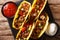Authentic tacos with minced beef, cheese and vegetables are served with sauces close-up. horizontal top view