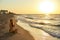 Authentic woman in swimsuit doing yoga padmasana on the beach in the morning. Real unretouched shape girl silhouette in