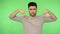 Authoritative brunette man pointing down with angry bossy expression and saying here. green background, chroma key